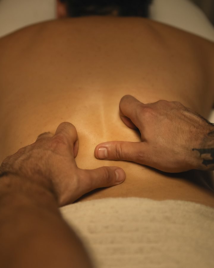 Manos trabajando la zona lumbar con presión de pulgares
